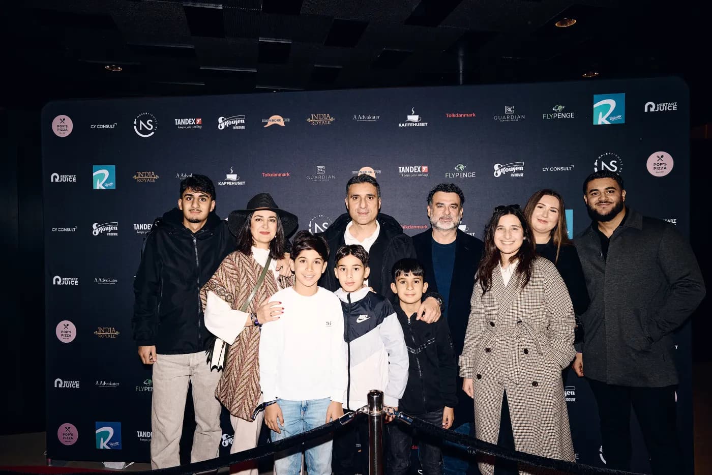 A family photographed at the sponsor wall at KOMBA 1.0